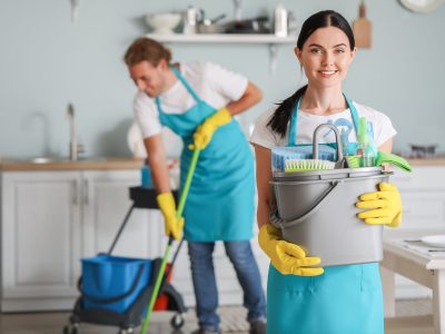 Female janitor with cleaning supplies in kitchen